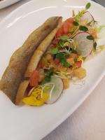 Un plato blanco con un sándwich y una ensalada. en Hotel Thuinerwaldele, en Vipiteno