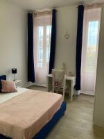 a bedroom with two beds and a table and two windows at Charmant F4 proche de la gare Saint Charles in Marseille