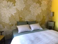 a bedroom with a bed with a flower wallpaper at La Gatille in Villié-Morgon