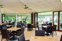 een restaurant met tafels en stoelen en mensen die aan tafels zitten bij Heron Island in Heron Island