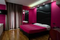 a pink bedroom with a bed with a black headboard at Sweet Central Hotel in Caserta