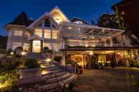 uma grande casa branca com um alpendre à noite em Secreto Boutique Hotel em Campos de Jordão