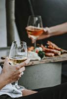 a person holding a glass of wine with a table of food at Ikaros Suites in Amoudara Herakliou
