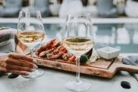 two glasses of wine next to a plate of food at Ikaros Suites in Amoudara Herakliou