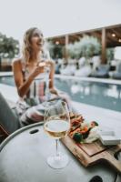 a woman sitting at a table with a glass of wine at Ikaros Suites in Amoudara Herakliou