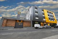 Una camioneta blanca estacionada frente a un edificio en Vinds Economic Hotel, en Ipatinga