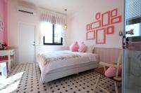 a bedroom with a bed with pink walls and a window at 1999 B&amp;B in Hualien City
