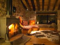 Una sala de estar con chimenea y un sofá. en Cabañas con Encanto, en San Roque de Ríomiera