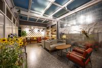 ein Wartezimmer mit Sofas, Tischen und Blumen in der Unterkunft Qiuguo Hutong Courtyard Hotel in Peking