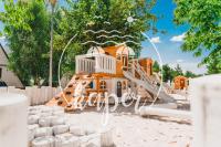 a playground with a slide in front of a house at Kaper Łeba - Domki Nad Morzem in Łeba