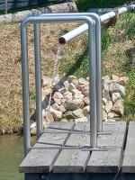 a metal railing on a boardwalk with a water fountain at Appartement Weingut Schoberhof in Bad Gleichenberg