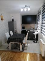 a kitchen and dining room with a table and chairs at Nenadovic Apartman in Obrenovac