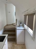 a kitchen with a staircase and a white refrigerator at Au coin des Hospices in Beaune