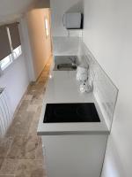 a white kitchen with a sink and a stove at Au coin des Hospices in Beaune