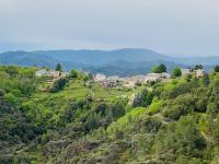 a group of houses on a hill with trees at Maison LGBT des Monts Bleus in Saint-Roman-de-Tousque