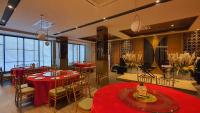 a restaurant with red tables and chairs and windows at Classie Hotel in Palembang