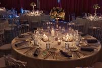 メリニャックにあるLe M & Spa Bordeaux Aéroport by Hôtels & Préférenceの結婚式で銀食器とキャンドルが置かれた丸いテーブル
