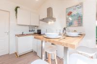 a kitchen with a counter with white cabinets and white stools at matcha wood - matcha home Koenigsmacker in Koenigsmacker