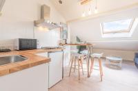 a kitchen with a sink and a counter with stools at matcha wood - matcha home Koenigsmacker in Koenigsmacker