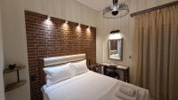 Un dormitorio con una cama con una pared de ladrillos. en Oikion Meteora Home 2, en Kalambaka