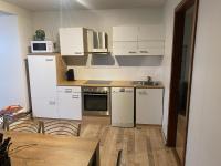 Una cocina con electrodomésticos blancos y suelo de madera. en Byggðarhorn, en Selfoss