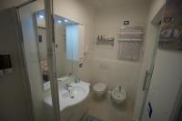 Un baño con lavabo, inodoro y ducha. en Ambra Apartment, en Isquia