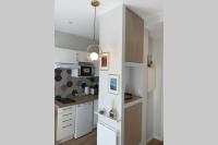 a kitchen with white cabinets and a pendant light at APPARTEMENT DE CHARME EN CENTRE VILLE in Toulouse