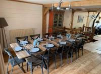 a large wooden table with black chairs in a room at Beautiful renovated chalet near ski resort France in Arâches-la-Frasse