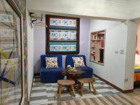 a living room with a blue couch and a table at Jilufugan B&amp;B in Taimali