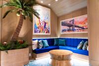 ein Wohnzimmer mit einem blauen Sofa und einer Palme in der Unterkunft Margaritaville Resort Times Square in New York