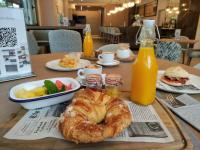 Una mesa con un plato de comida y un bagel y jugo. en Aparthotel Attica21 As Galeras, en Bastiagueiro