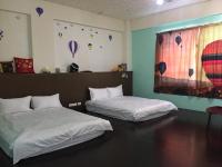 two beds in a room with balloons on the wall at Guanshan Fukuda Homestay in Guanshan
