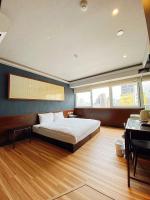 a bedroom with a large bed and a piano at Hotel 6 - Ximen in Taipei