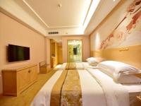 Un dormitorio grande con dos camas y un televisor de pantalla plana. en Vienna Hotel Xining Shengli Road, en Xining