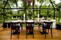 a table in a greenhouse with chairs and candles at Aries Hotel & SPA Wisła in Wisła