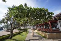 a bride and groom standing under a tree in front of a building at Katathani Phuket Beach Resort - SHA Extra Plus in Kata Beach