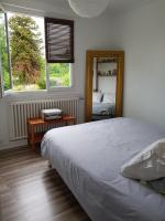 a bedroom with a large bed and a mirror at La Bodega in Arnage