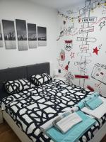 a bedroom with a bed with a black and white comforter at Nenadovic Apartman in Obrenovac