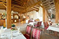 a restaurant with white tables and red chairs at Gästehaus Kloster Nimbschen in Grimma
