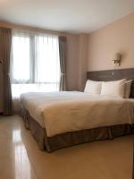 a bedroom with a large bed with a large window at Hotel Leisure Beitou in Taipei