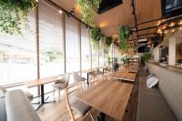 犬山市にあるホテルミュースタイル犬山エクスペリエンスの木製のテーブルと椅子、大きな窓のあるレストラン