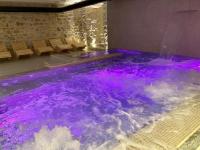 una piscina de agua púrpura en una habitación con bancos en Spa &amp; Wellness by Des Anglais &quot; Accesso SPA compreso&quot;, en San Remo