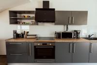 a kitchen with gray cabinets and a counter top with a microwave at Villa Danijela in Malinska