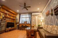 a living room with a couch and a ceiling fan at 阿鑫民宿 in Jinning