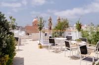 a patio with tables and chairs on a roof at Plaza Mina Suites - Adults Recommended by Luxury Suites Cadiz in Cádiz