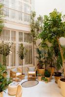 a courtyard with chairs and potted plants at Plaza Mina Suites - Adults Recommended by Luxury Suites Cadiz in Cádiz