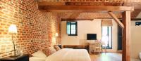 a brick walled room with a bed and a couch at Hotel The Lodge Heverlee in Leuven