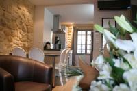a kitchen and living room with a table and chairs at Le Porche de Sarlat in Sarlat-la-Canéda