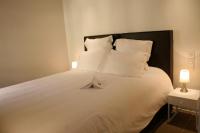 a large white bed with white pillows and a lamp at Le Porche de Sarlat in Sarlat-la-Canéda