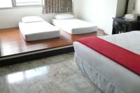 two twin beds in a room with wooden floors at Kuo Kuang Hostel in Hualien City